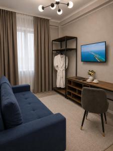 a living room with a blue couch and a tv at Urban Hotel in Bishkek
