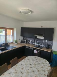 a kitchen with black cabinets and a table in it at Karolingerweg Gäst Haus in Lauterhofen