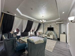 a living room with a couch and a table at GRAND SARBON HOTEL in Qarshi +8 photos
