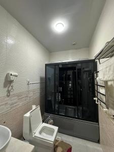a bathroom with a toilet and a sink at GRAND SARBON HOTEL in Qarshi