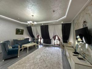 a living room with a couch and a fireplace at GRAND SARBON HOTEL in Qarshi