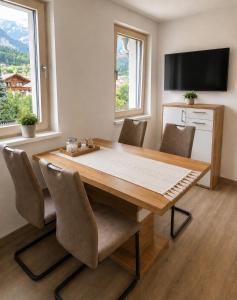 a dining room with a wooden table and chairs at Apartment Kaiblingblick in Haus im Ennstal
