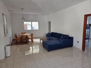 a living room with a blue couch and a table at Janis Home in Chrani