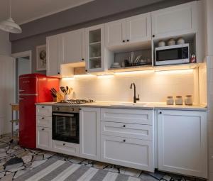 a kitchen with white cabinets and a red refrigerator at Il Cuore di Santa è tutto blu in Santa Margherita Ligure