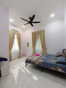 a bedroom with a bed and a ceiling fan at Private Pool Homestay Kota Bharu 3 Bilik Tidur Muat 12 Tetamu in Kota Bharu +24 photos