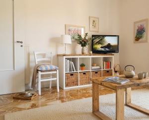 a living room with a tv and a table at Il Cuore di Santa è tutto blu in Santa Margherita Ligure
