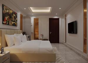 a bedroom with a white bed and a television at Market Ben Thanh Kas Hotel Passion in Ho Chi Minh City