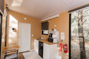 a kitchen with a refrigerator and a microwave at The Hideaway at Novena Pines by Tiny Away in Thulimbah
