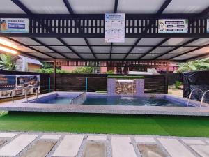 a swimming pool in a pavilion with at Private Pool Homestay Kota Bharu 3 Bilik Tidur Muat 12 Tetamu in Kota Bharu