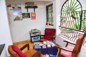 a living room with a table and chairs and a window at Jes Guest House in Majorda