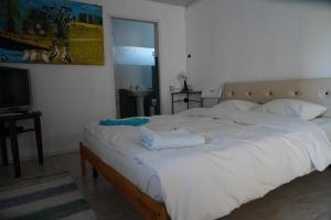 a large white bed in a room with a television at Casa 9 in Sfântu Gheorghe