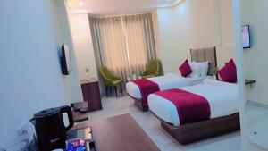 a hotel room with two beds and a television at Hotel Harsh Vilas-Near Tajmahal Agra in Agra