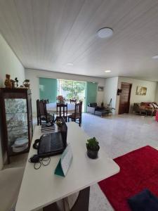 a living room with a table with a laptop on it at Quarto privativo em Guriri casa de praia in São Mateus