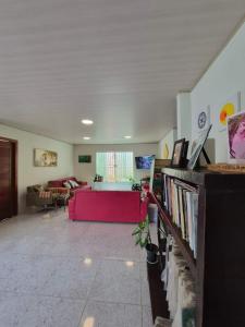 a living room with a couch and a red couch at Quarto privativo em Guriri casa de praia in São Mateus