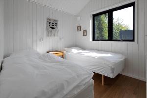 a bedroom with two white beds and a window at 13397-Vig-Lyngkrogen-21 in Vig