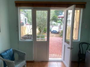 an open door leading to a patio with a driveway at The Rose and Olive in Cradock +3 photos