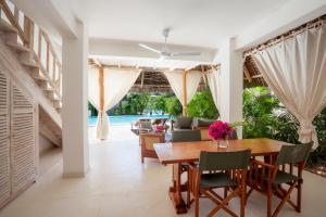 a dining room with a wooden table and chairs at Swordfish Villas in Malindi