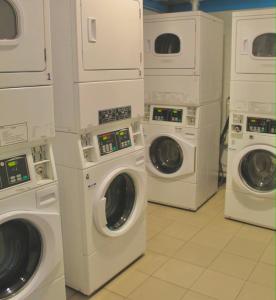 four washers and dryers in a laundry room at 790 on George Backpackers in Sydney