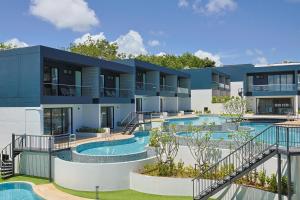 an exterior view of a building with two swimming pools at Elite Suites Villas Maikhao Phuket in Mai Khao Beach