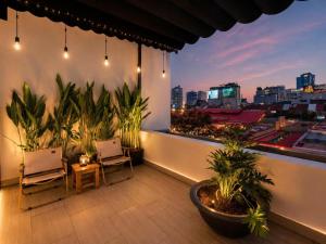 a balcony with a view of a city at night at Ben Thanh Luxury Hotel - Premium Kas Dilly & Spa in Ho Chi Minh City