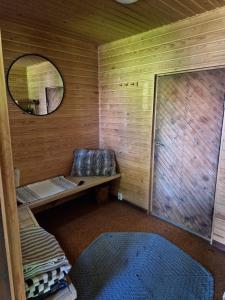 a small room with a mirror and a bench in a cabin at Cute old garden cottage in Kirkkonummi +32 photos