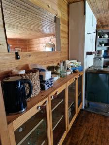 a kitchen with wooden cabinets and a counter top at Cute old garden cottage in Kirkkonummi