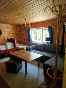a living room with a couch and a table at Cute old garden cottage in Kirkkonummi
