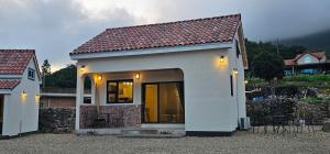 a small white tiny house with a roof at Dara House Private Pension in Jangheung