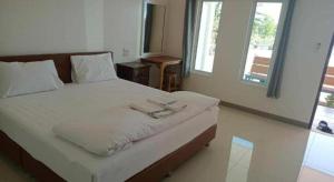 a bedroom with a bed with two towels on it at Prakaithong hotel in Amphoe Sawang Daen Din
