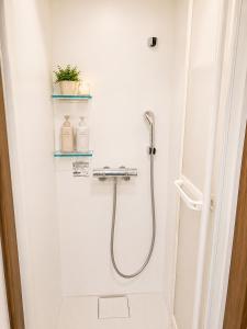 a shower in a white bathroom with a glass door at ペンションハートウォーマー in Myoko +46 photos