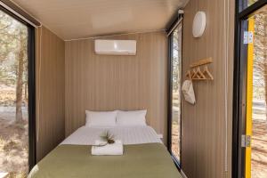 a bedroom in a tiny house with a bed at Novena Pines by Tiny Away in Thulimbah