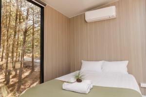 a bedroom with a bed and a large window at Novena Pines by Tiny Away in Thulimbah