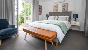 a bedroom with a large bed and a chair at Three Oaks in Red Hill