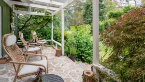 a patio with two chairs and a table at Three Oaks in Red Hill