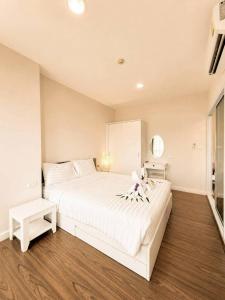 a white bedroom with a large white bed and a window at Courtyard khaoyai by August in Khao Yai +24 photos