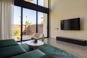 a living room with a couch and a tv at Ecoverse Resort & Residence by OXO - Nyanyi Beach, Bali in Cemagi