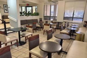 a restaurant with tables and chairs and tables and chairs at Quality Inn At the Mall - Valdosta in Valdosta