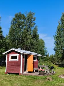 a small red and white shed with a picnic table at Northern Cabin in Havukkavaara