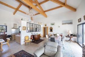 a living room with white walls and wooden ceilings at Villa Helychrisa in Aléria