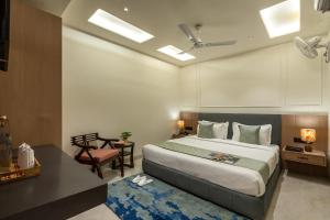 a bedroom with a large bed and a desk and a table at Perfectstayz Premium Vrindavan - Near Prem Mandir in Vrindāvan +85 photos
