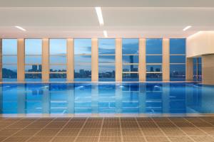 a swimming pool in a building with windows at Hilton Wenzhou in Wenzhou