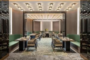 a dining room with tables and chairs at Hilton Wenzhou in Wenzhou