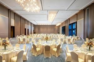a banquet hall with white tables and chairs and chandeliers at Hilton Wenzhou in Wenzhou +42 photos