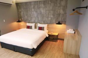 a bedroom with a large white bed with two pillows at Sans Hotel in Ban Rong Chang +166 photos