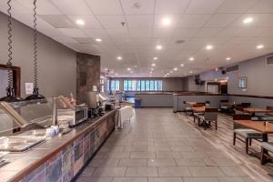 a restaurant with a counter and some tables and chairs at Quality Inn & Suites in Williamsburg