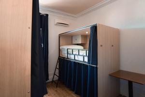 a closet with a blue curtain in a room at Rosalma Hostel in Porto