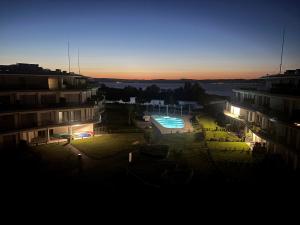 a view of a building with a pool at night at Szemesbay Serenity Apartman in Balatonszemes +10 photos
