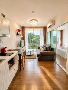 a kitchen and living room with a couch and a table at Courtyard khaoyai by August in Khao Yai