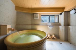 a bath tub filled with water in a room at 江ノ島の島内で一棟貸し一日一組限定はまさき旅館 in Fujisawa +92 photos