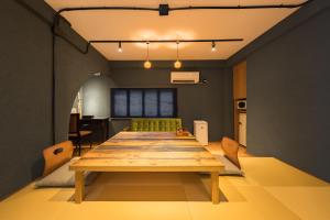 a long wooden table in a room with a kitchen at 江ノ島の島内で一棟貸し一日一組限定はまさき旅館 in Fujisawa